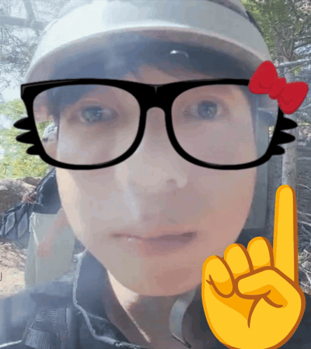 A Person Wearing Glasses And A Hat With A Red Bow On Them GIF