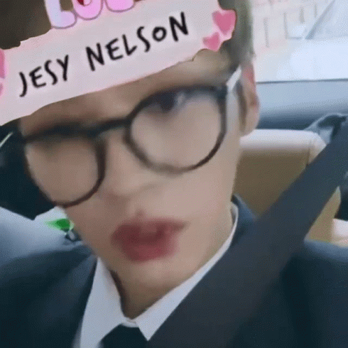 A Person Wearing Glasses And A Headband With Jesy Nelson Written On It GIF
