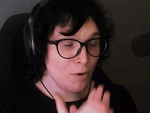 A Person Wearing Glasses And Headphones Is Making A Face GIF