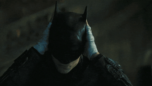 A Person Wearing Gloves Covering Their Face With Their Hands GIF