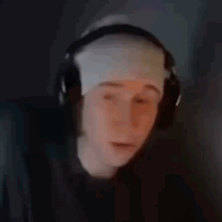 a person wearing headphones and a bandage on their head is looking at a computer screen .