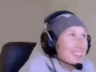 a person wearing headphones and a beanie is smiling .