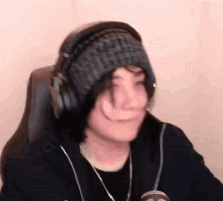 A Person Wearing Headphones And A Knitted Hat Is Sitting In A Chair . GIF