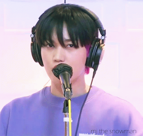 A Person Wearing Headphones Is Singing Into A Microphone With The Words " Mj The Snowman " Below Them GIF