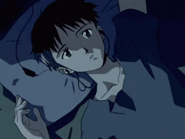 A Person Wearing Headphones Laying On A Bed With A Blue Shirt On GIF