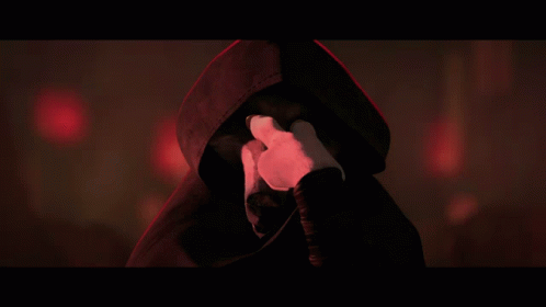 A Person With A Hood On Covering Their Face With Their Hands GIF
