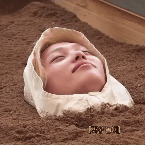 A Person With A Hood On Their Head Is Buried In The Dirt GIF