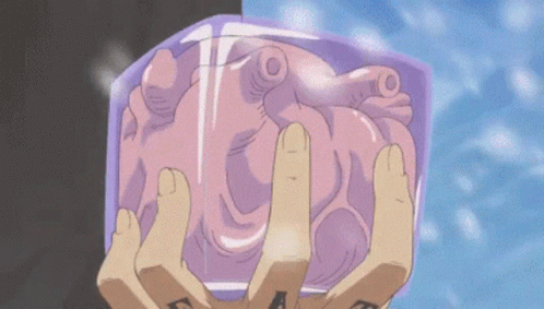 A Person With A Tattoo On Their Hand Is Holding A Heart In Their Hands GIF