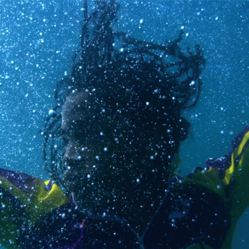 A Person With Dreadlocks Is Swimming Underwater GIF