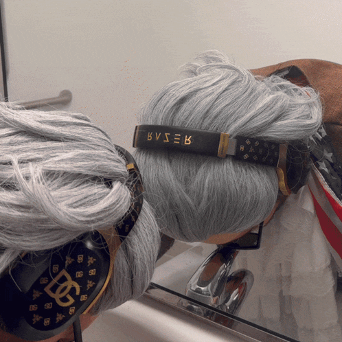 A Person With Gray Hair Wearing Headphones With Bvser Written On Them GIF