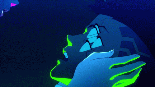 A Person With Neon Green Paint On Their Face Is Kissing Another Person In A Dark Room GIF