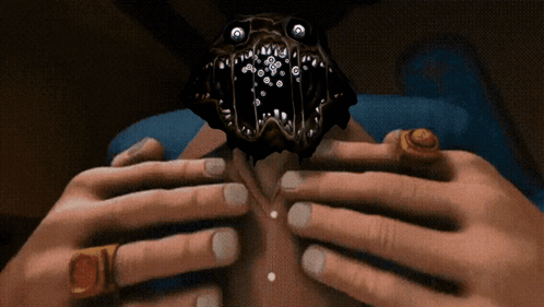 A Person With Rings On Their Fingers Is Holding A Monster GIF