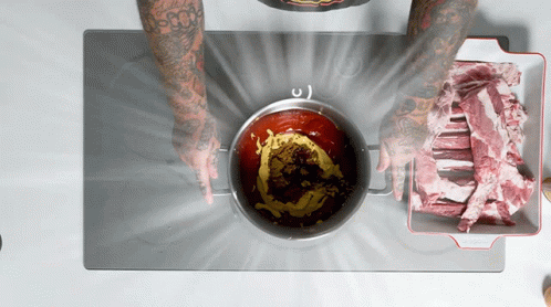 A Person With Tattoos On Their Arms Is Cooking On A Stove Top GIF