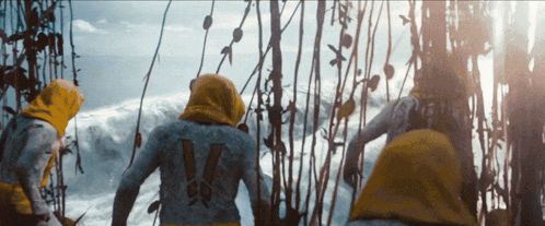 A Person With The Number 14 On Their Back Stands In Front Of A Body Of Water GIF