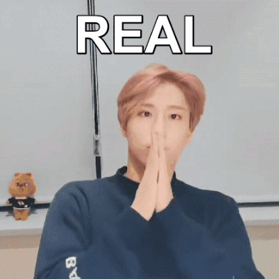 A Person With Their Hands Folded In Front Of Their Face And The Word Real Above Them GIF