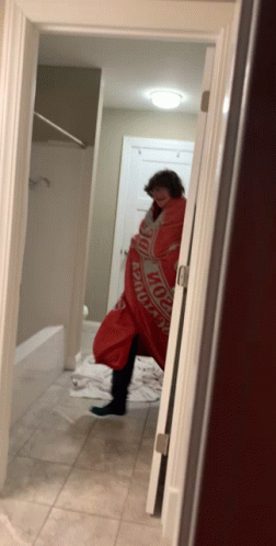 A Person Wrapped In A Budweiser Blanket In A Bathroom GIF