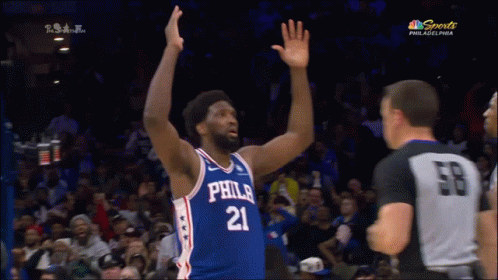 A Philadelphia Basketball Player With His Hands In The Air During A Game GIF