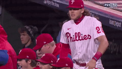 A Phillies Baseball Player Stands In The Dugout With His Teammates GIF