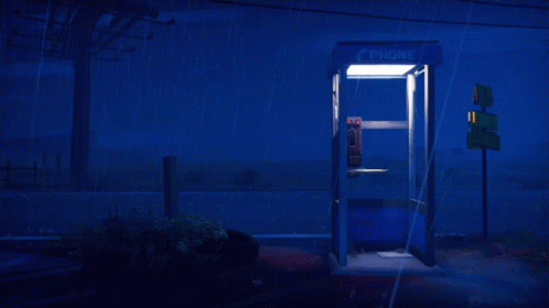 A Phone Booth Is Lit Up In The Dark GIF