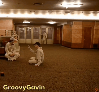 A Photo Of A Man Sitting On The Floor With Groovy Gavin Written On The Bottom GIF
