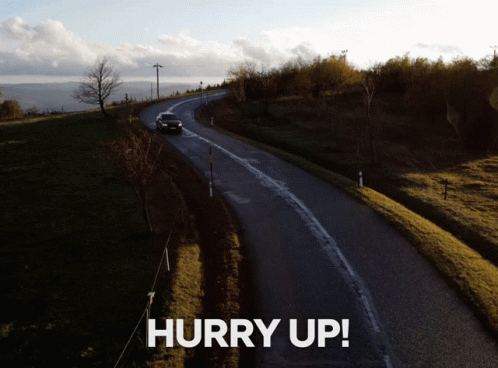 A Picture Of A Car Driving Down A Road With The Words Hurry Up Above It GIF