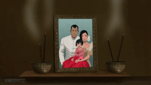 A Picture Of A Family Is Framed On A Table With Two Bowls Of Incense In Front Of It GIF