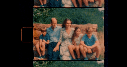 A Picture Of A Family Sitting On A Rock With A Black Background GIF