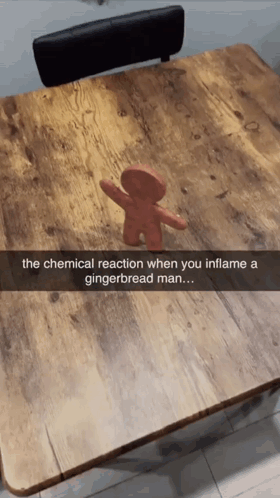 A Picture Of A Gingerbread Man On A Wooden Table GIF
