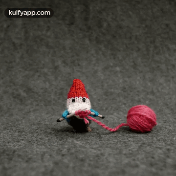 A Picture Of A Gnome Knitting With The Website Kulfyapp.com In The Upper Right Corner GIF
