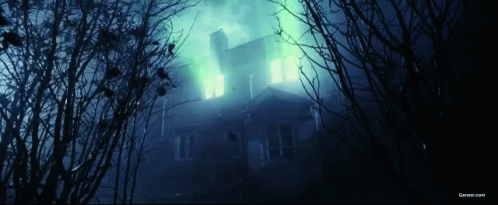 A Picture Of A Haunted House With A Green Light Coming From The Windows GIF