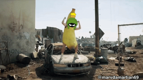 a picture of a man dressed as marvin the martian standing on a car