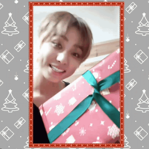 A Picture Of A Man Holding A Pink Gift Box With A Green Ribbon GIF