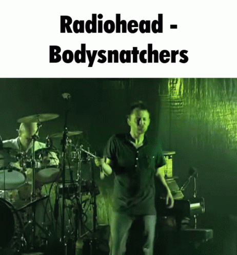 A Picture Of A Man On Stage With The Words Radiohead Bodysnatchers GIF