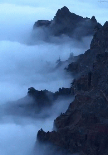 A Picture Of A Mountain Covered In Clouds With The Words Agreeing Below It GIF
