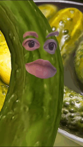 A Picture Of A Pickle With A Face On It And A Bowl Of Pickles In The Background GIF