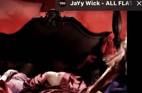 A Picture Of A Woman Laying On A Bed With The Words Jayy Wick All Flat X On The Bottom GIF