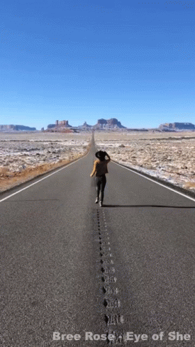 A Picture Of A Woman Walking Down An Empty Road With The Words Bree Rose Eye Of She Below Her GIF