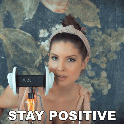 A Picture Of A Woman With Ear Buds And The Words Stay Positive GIF