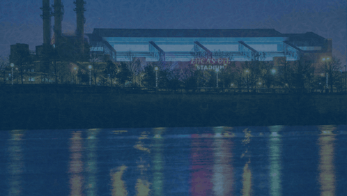 a picture of lucas oil stadium with a river in the background