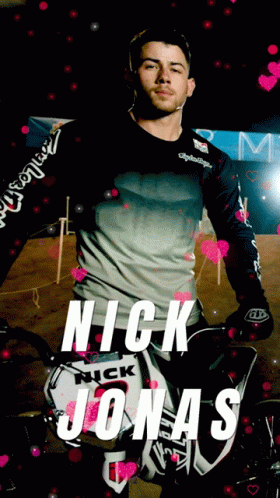 A Picture Of Nick Jonas With A Motorcycle In The Background GIF