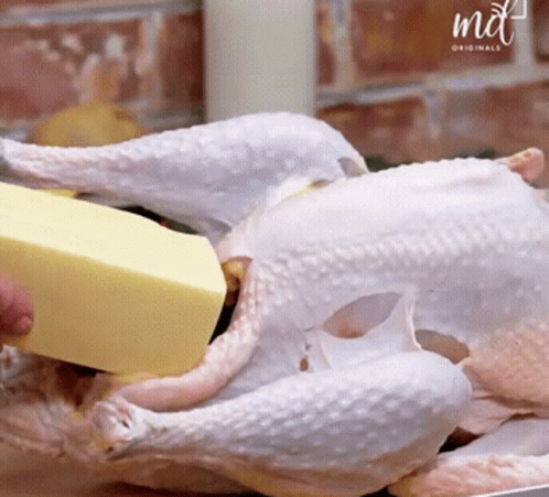 A Piece Of Butter Is Being Poured On A Chicken By A Md Originals Logo GIF