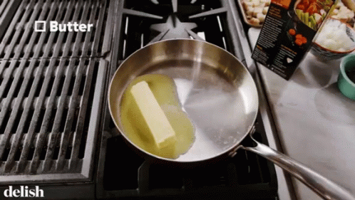 A Piece Of Butter Is In A Frying Pan On A Stove Top GIF