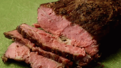 A Piece Of Meat That Has Been Sliced On A Cutting Board GIF