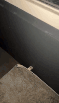 A Piece Of Paper Is Laying On A Table Next To A Wall GIF