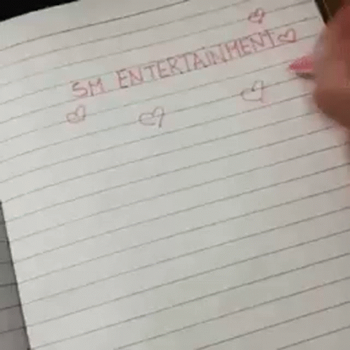 A Piece Of Paper With A Smiley Face On It Is On A Table . GIF