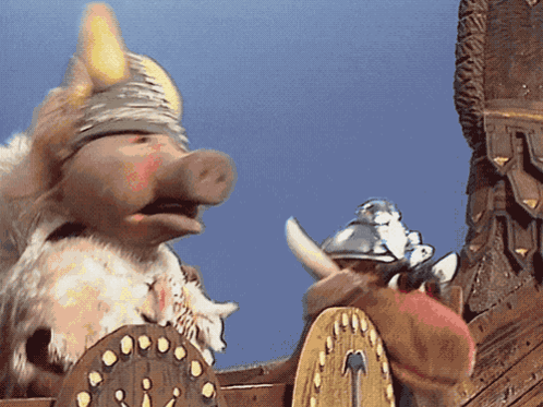 A Pig Wearing A Viking Helmet Is Standing Next To A Shield GIF