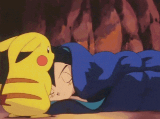 a pikachu is standing next to a person sleeping in a blue blanket