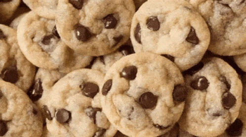A Pile Of Chocolate Chip Cookies Looks Like A Pile Of Faces GIF