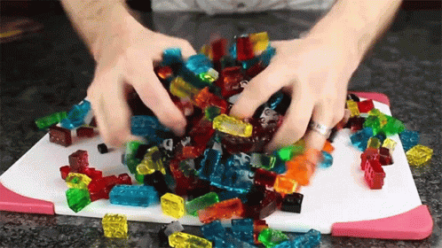 A Pile Of Gummy Bears On A Cutting Board GIF