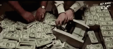 A Pile Of Money Is On A Table And People Are Counting It . GIF